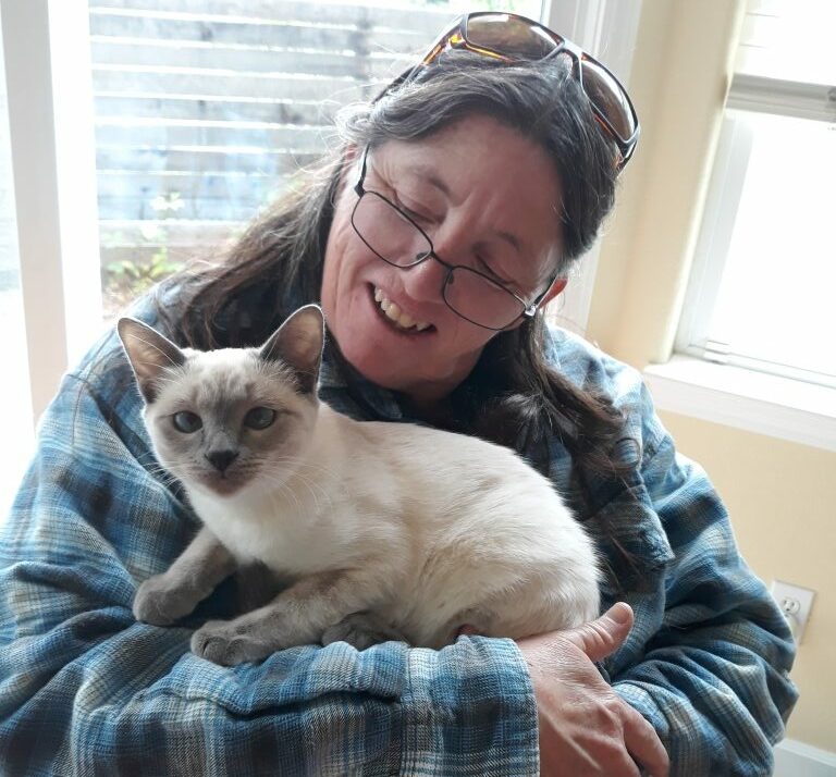 Pet sitter holding a Siamese kitten